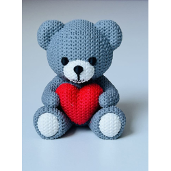 Ourson en tricot avec coeur rouge .